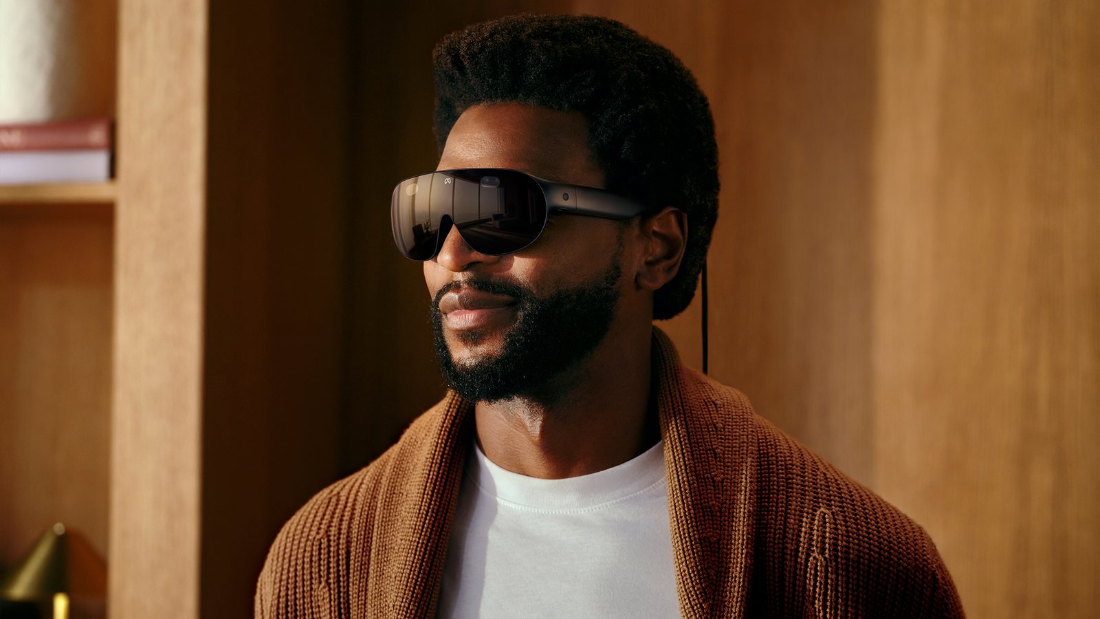 A man wearing Meta VR Glasses, a slim dark visor with thin arms and a cable running from the right arm