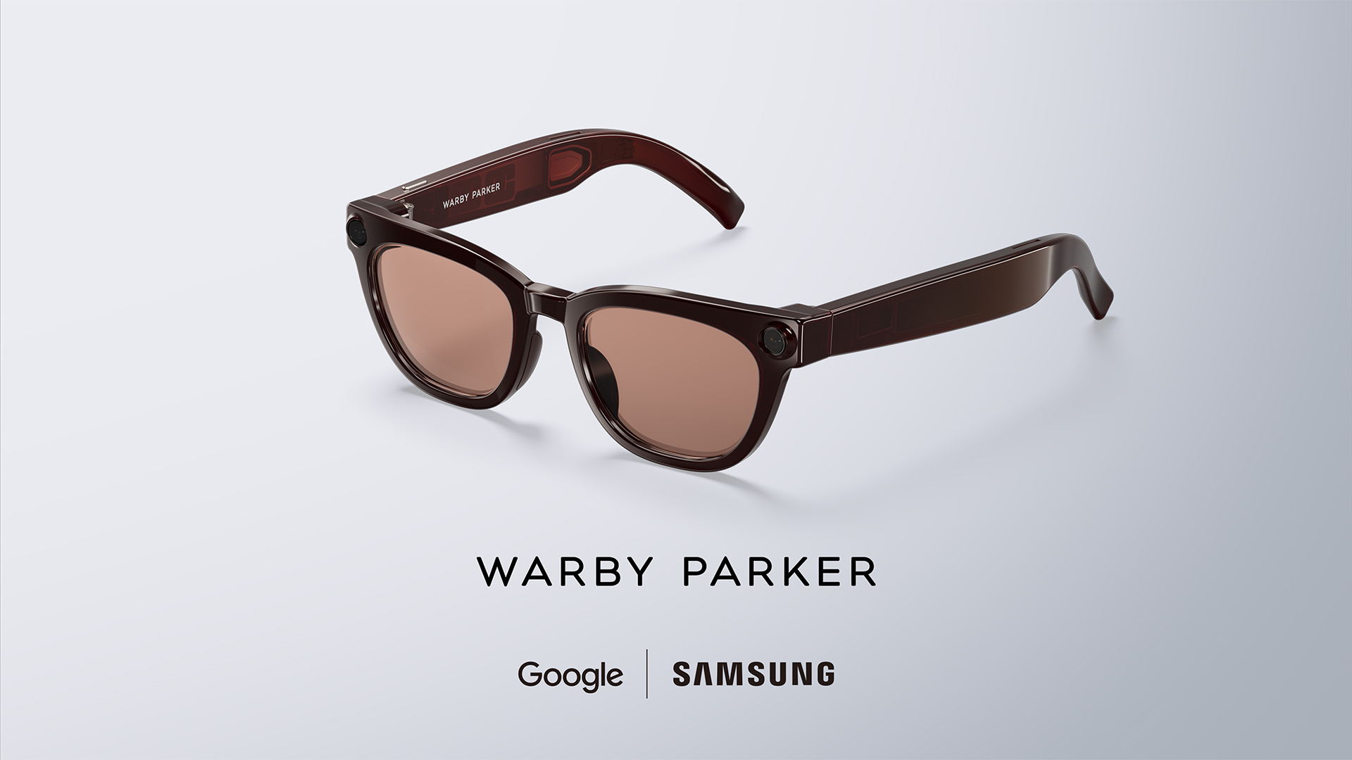 Brown Warby Parker frame of the Google and Samsung audio glasses with tinted lenses and a camera lens at each hinge, above the Google and Samsung logos